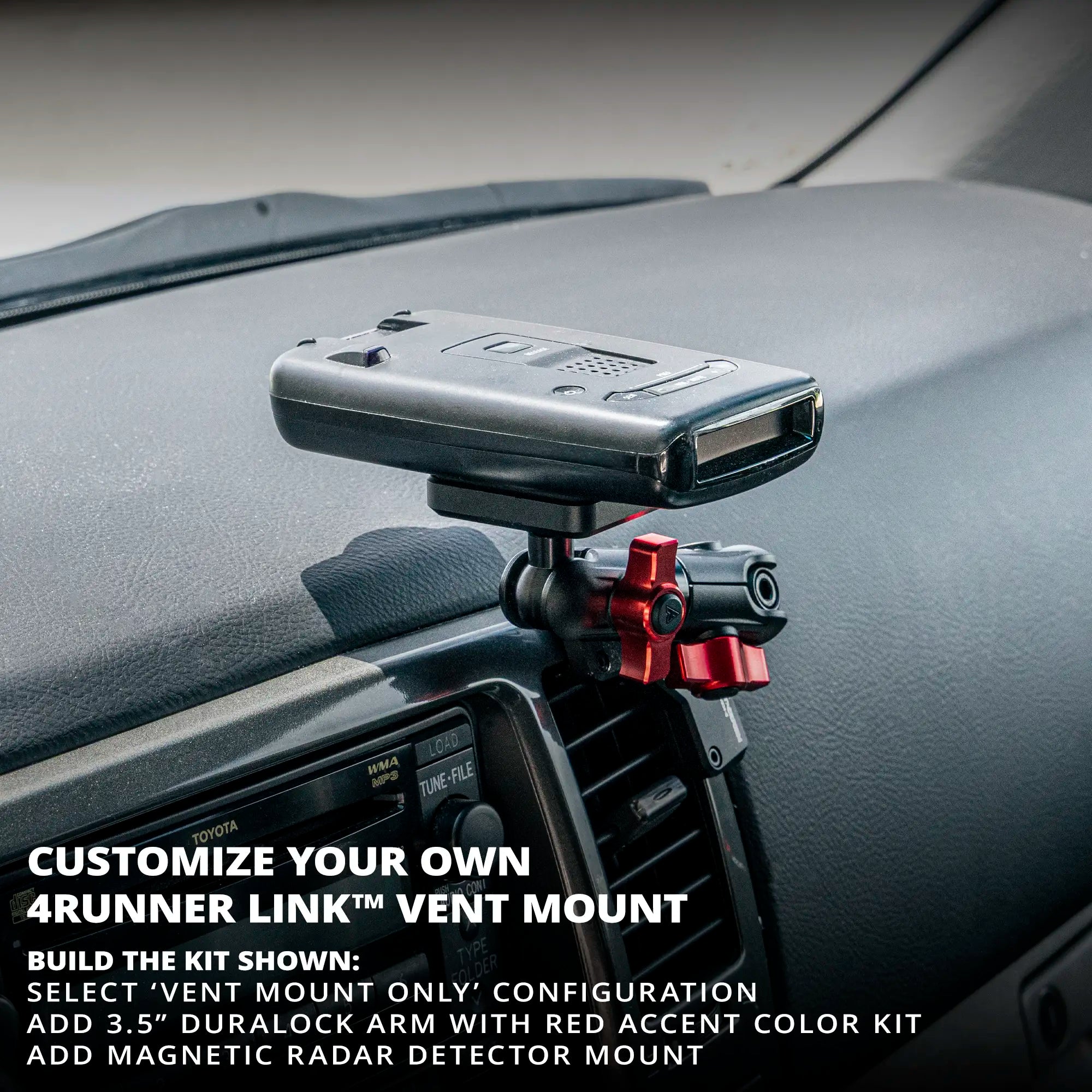 2003-2009 4 Runner Vent Mount. A black car radar detector mounted on a dashboard air vent bracket with a red adjustment knob, installed inside a vehicle.