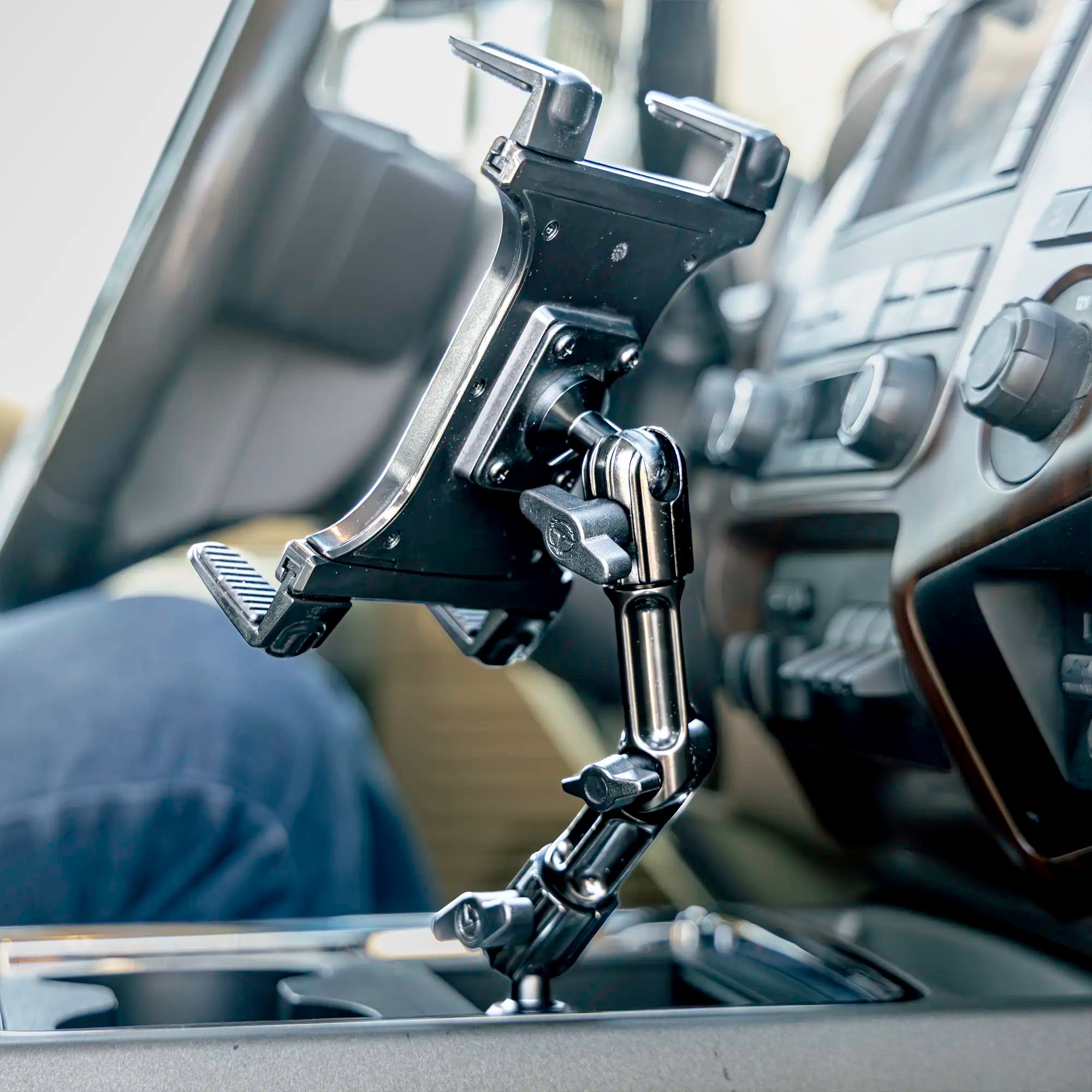 Black tablet mount with adjustable arm mounted in the center console of a Ford Super Duty